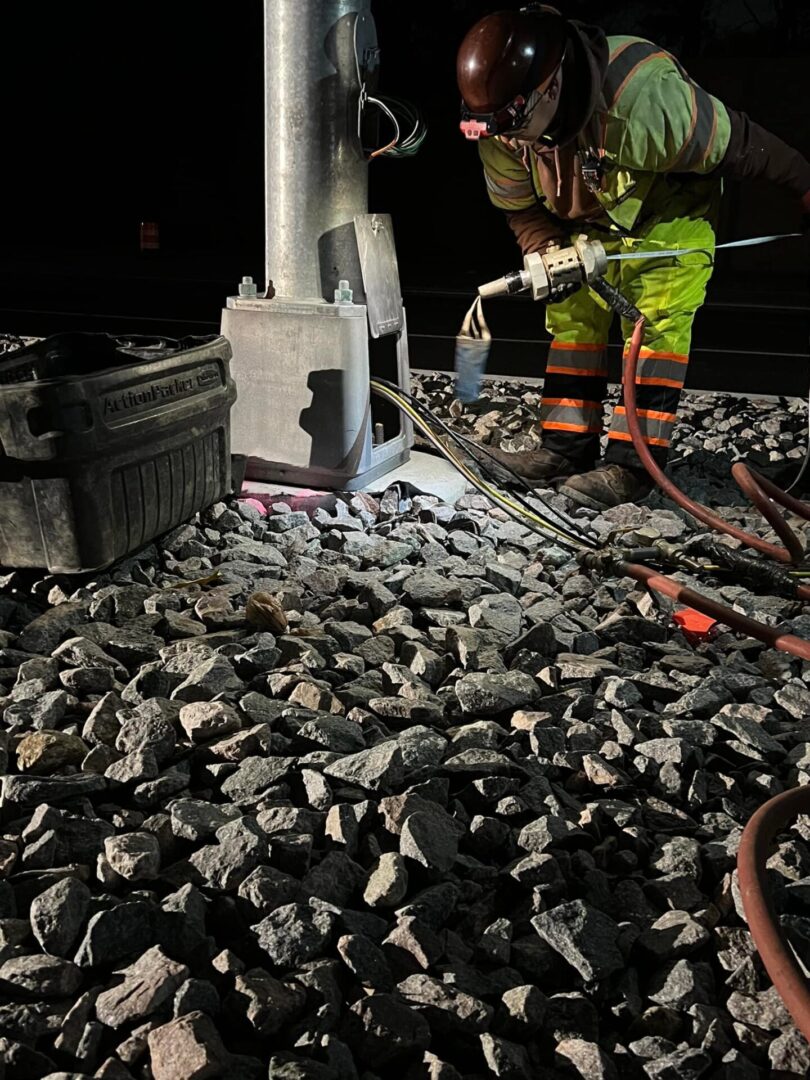 Worker repairing a light pole at night.